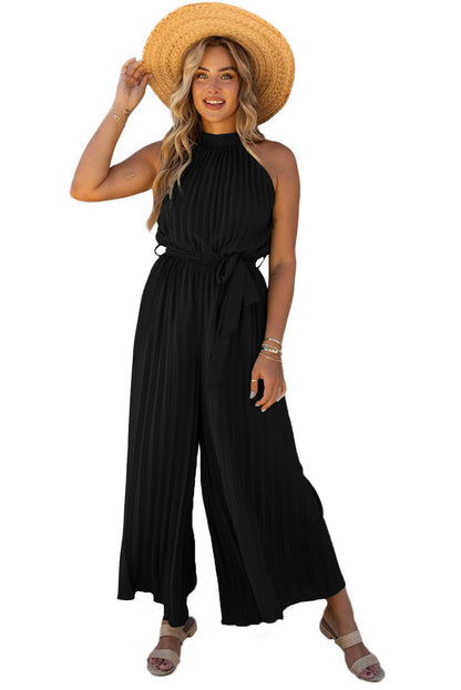 Black halter-neck pleated wide-leg jumpsuit with belt.
