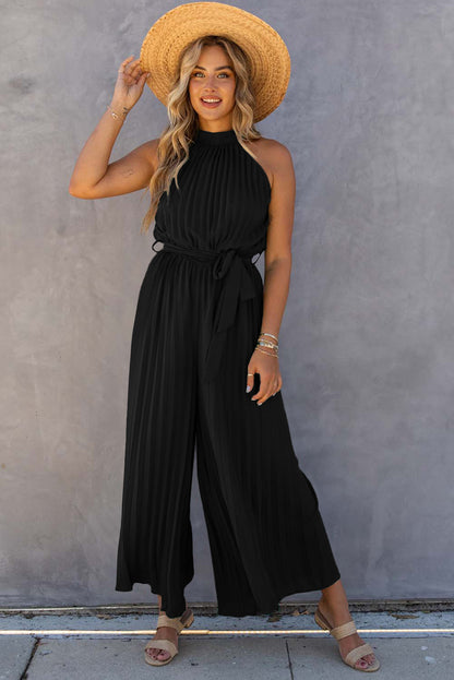 Black halter-neck pleated wide-leg jumpsuit with belt.