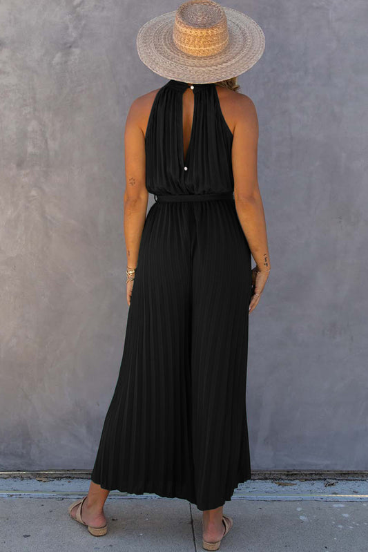 Black halter-neck pleated wide-leg jumpsuit with belt.